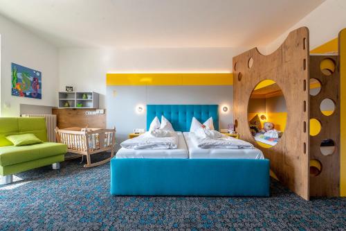 a bedroom with a bed and a play room at Familotel Mein Krug in Warmensteinach