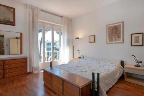 Un dormitorio con una cama y una cómoda y una ventana. en Residenza la Principina by Mmega, en Lido di Camaiore