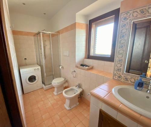 a bathroom with a toilet sink and a washing machine at Pacentro Dimora del Castello in Pacentro