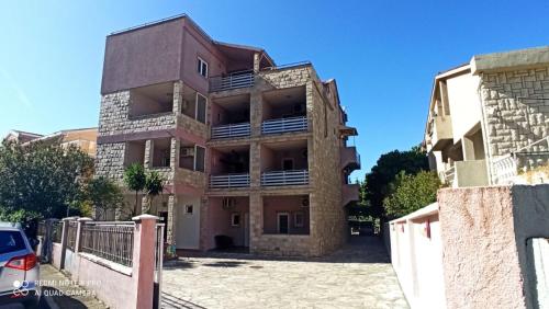 a building with a parking lot in front of it at Kuća Todorović in Budva