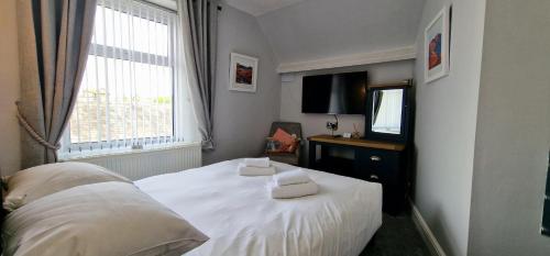 a bedroom with a bed with two towels on it at Bonny Brae House by Woodland Park in Windermere