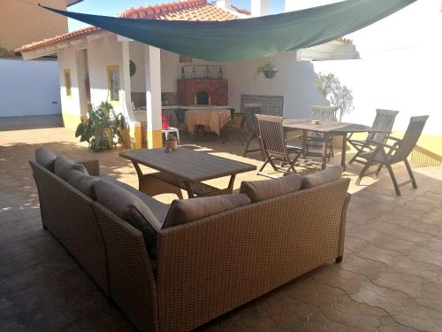 a patio with a couch and a table and chairs at Casa dos Pingos de Mel in Aveiro