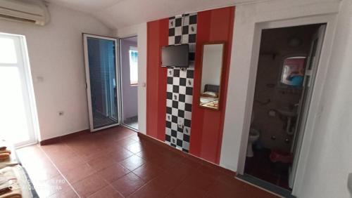 a hallway with a red and black tile accent wall at Kuća Todorović in Budva