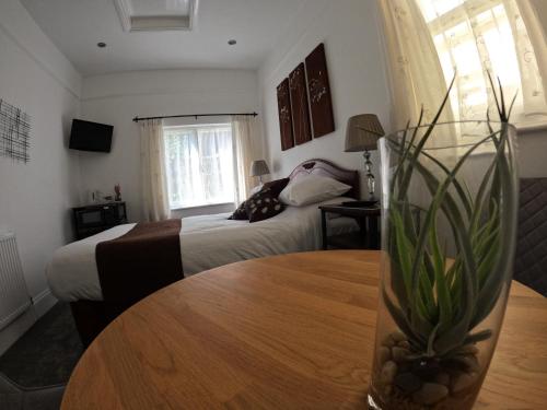 a hotel room with a bed and a table with a vase at The Grove Falmouth in Falmouth
