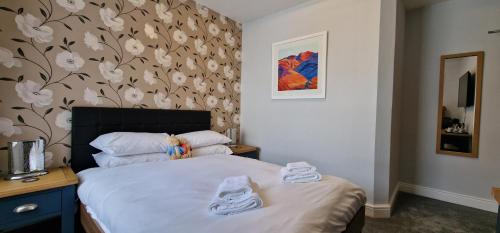 a bedroom with a bed with two towels on it at Bonny Brae House by Woodland Park in Windermere