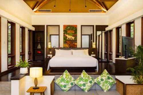 a bedroom in a villa with a bed and a couch at Angkor Green Gardens by Dara in Siem Reap