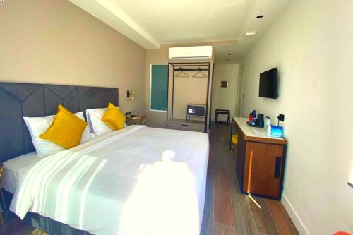 a bedroom with a large bed with yellow pillows at Cinematique in Mosta
