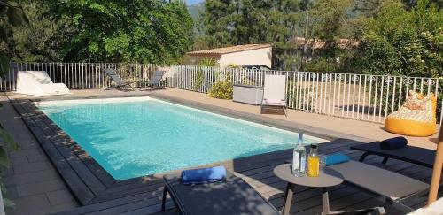 - une piscine avec une table et des chaises à côté dans l'établissement Villa Ribba 10 pers piscine 5 min plage en voiture, à Porto-Vecchio