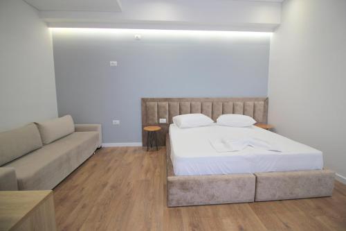 a bedroom with a bed and a couch at JUER Hotel in Bajkaj