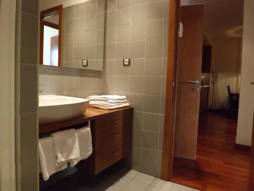 y baño con lavabo y espejo. en Roca Nevada Resort, en Villanúa