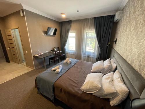 ein Hotelzimmer mit einem großen Bett und Kissen in der Unterkunft Khan Boutique Hotel in Almaty