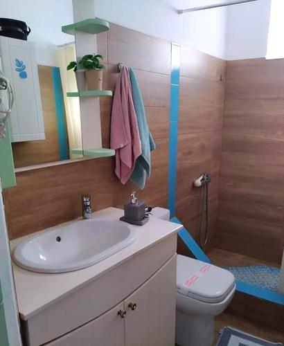 a bathroom with a sink and a toilet at Ornella's & Laura's secret place in Livadia