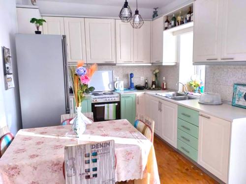 a kitchen with a table with a vase of flowers on it at Ornella's & Laura's secret place in Livadia