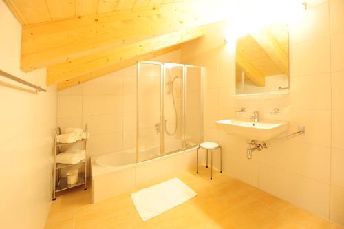a bathroom with a shower tub and a sink at AlpeLux Appartement an der Skipiste in Jerzens