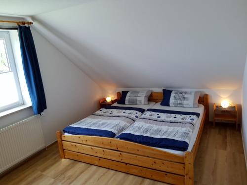 a bedroom with a bed with blue and white sheets at Haus Tanneck, Nr 14 in Kellenhusen