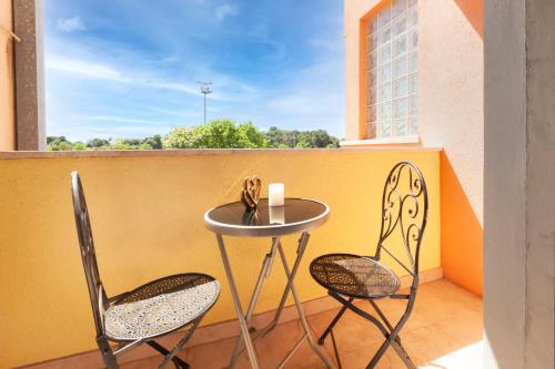 een kleine tafel en 2 stoelen op een balkon bij Guest House Casa Santin in Rovinj