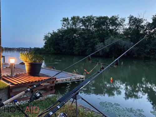 a fishing rod in the water next to a dock at STÉG64 - Ráckeve - hostAID in Ráckeve