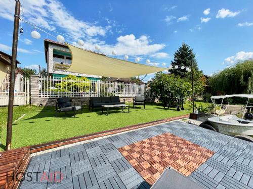 a backyard with a patio with a tan canopy at STÉG64 - Ráckeve - hostAID in Ráckeve