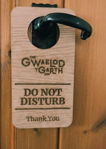 a wooden door with a do not disturb sign on it at The Gwaelod y Garth Inn in Cardiff
