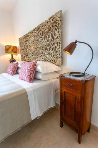 a bedroom with a bed and a lamp on a nightstand at Masseria Ferarelli Trepizzi in Diso