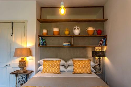 a bedroom with a bed with two pillows and shelves at Masseria Ferarelli Trepizzi in Diso