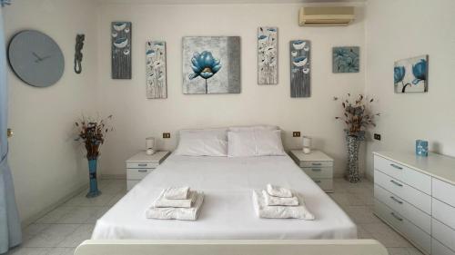 um quarto com uma grande cama branca com toalhas em Welcomely - Casa del Minatore 2 em Gonnesa