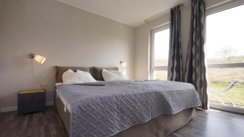 ロープベにあるFerienwohnung 4 im Strandhaus Lobbeの大きな窓のあるベッドのある寝室