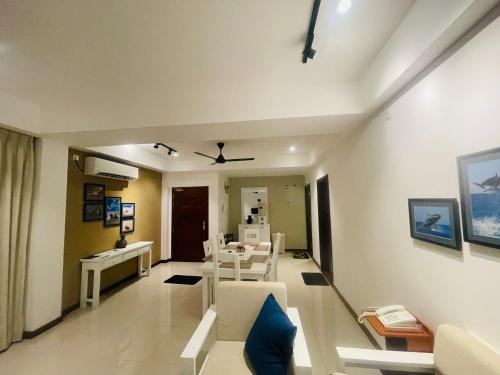 Trincomalee Ocean Front Condos في ترينكومالي: غرفة معيشة بأثاث أبيض ومروحة سقف