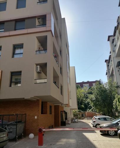 un edificio de apartamentos con un aparcamiento enfrente en APARTMAN ANA, en Niš