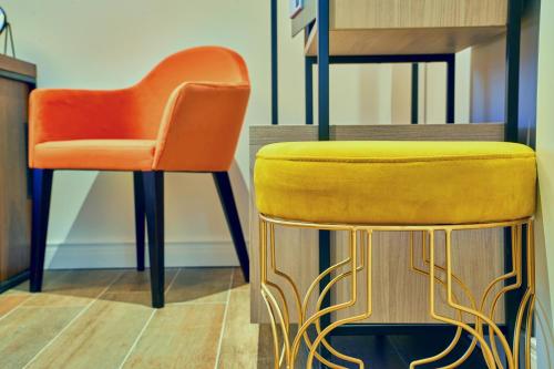 an orange chair and a stool in a room at Cinematique in Mosta