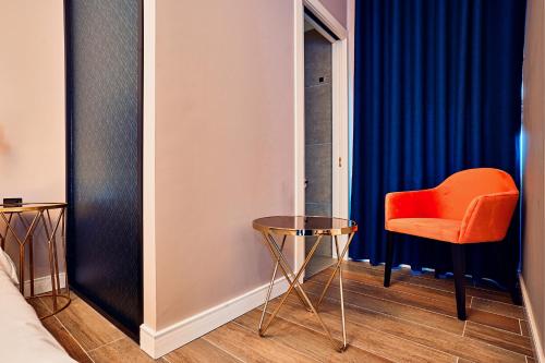 an orange chair and a table in a room at Cinematique in Mosta