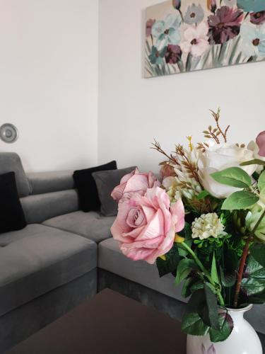 普拉的住宿－Apartment Eva，客厅配有沙发和鲜花花瓶