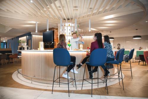 a group of women sitting at a bar in a restaurant at Novotel Le Havre Centre Gare in Le Havre