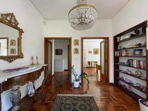 sala de estar con lámpara de araña y suelo de madera dura en Lumachella B&B, en Cefalú