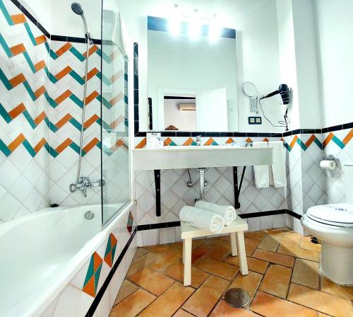 a bathroom with a sink toilet and a mirror at Hotel Rosa De oro in Granada