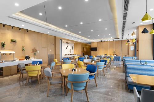 a restaurant with blue and yellow chairs and tables at Holiday Inn Express Chengdu Xindu by IHG in Chengdu