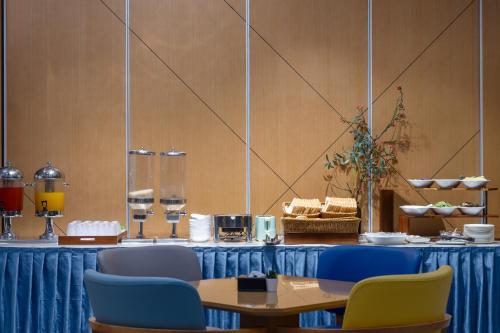 a table with a blue table cloth and blue chairs at Holiday Inn Express Chengdu Xindu by IHG in Chengdu