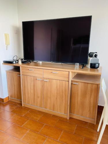 - une grande télévision à écran plat sur un centre de divertissement en bois dans l'établissement Studio Plage, à Marseille