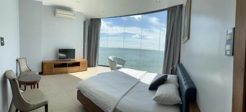una camera da letto con una grande finestra con vista sull'oceano di Nancy Grand Osaky Condotel Vung Tau a Vung Tau