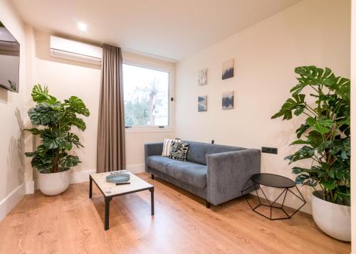 sala de estar con sofá y 2 macetas en BILBAO RIVERSIDE by STAYNN APARTMENTS, en Bilbao