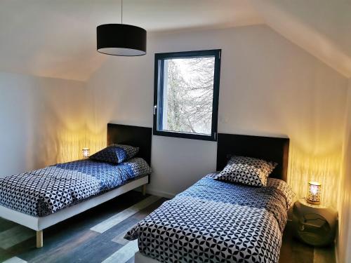 um quarto com 2 camas e uma janela em Maison de 3 chambres avec vue sur la ville jardin amenage et wifi a Le Fied em Le Fied