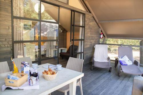 a table and chairs on the porch of a tiny house at Paradù EcoVillage & Resort in Marina di Castagneto Carducci