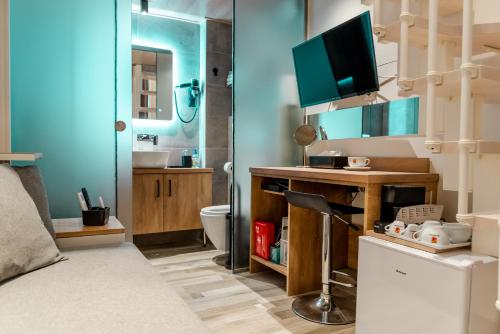 baño con aseo y escritorio con TV. en BLACKHAUS YOUNG MINI, en Tesalónica