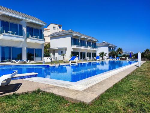 a large swimming pool in front of a house at Ocean Suites Luxury Apartments in Protaras