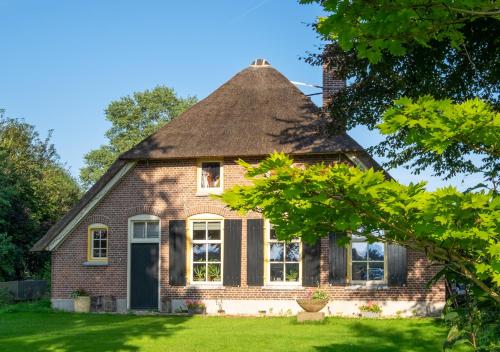 an old brick house with a thatched roof at Rumah Indo Garden in Wilp
