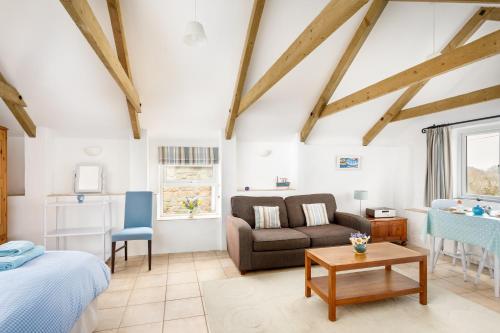 a room with a bed and a couch and a table at Little Pengelly Farm in Crowan