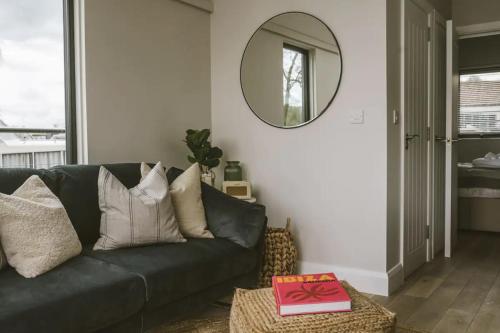 a living room with a black couch and a mirror at Water Cabin With Water Sports Equipment and Bikes, Bath in Bristol