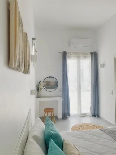 a bedroom with a bed and a window at Kirki Rooms by the sea in Parikia