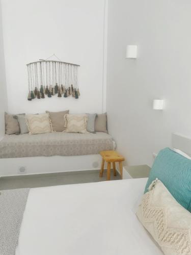 a white room with a couch and a chair at Kirki Rooms by the sea in Parikia