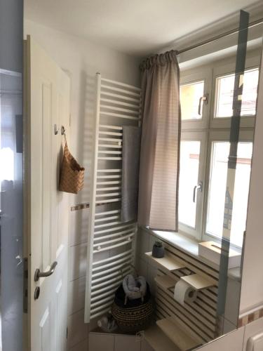 a bathroom with a mirror and a window and a sink at Ferienwohnung am Griesgarten in Bamberg